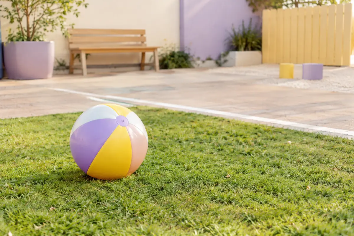 Ballon posé sur une pelouse dans un espace extérieur dégagé, prêt pour un jeu adapté au terrain.
