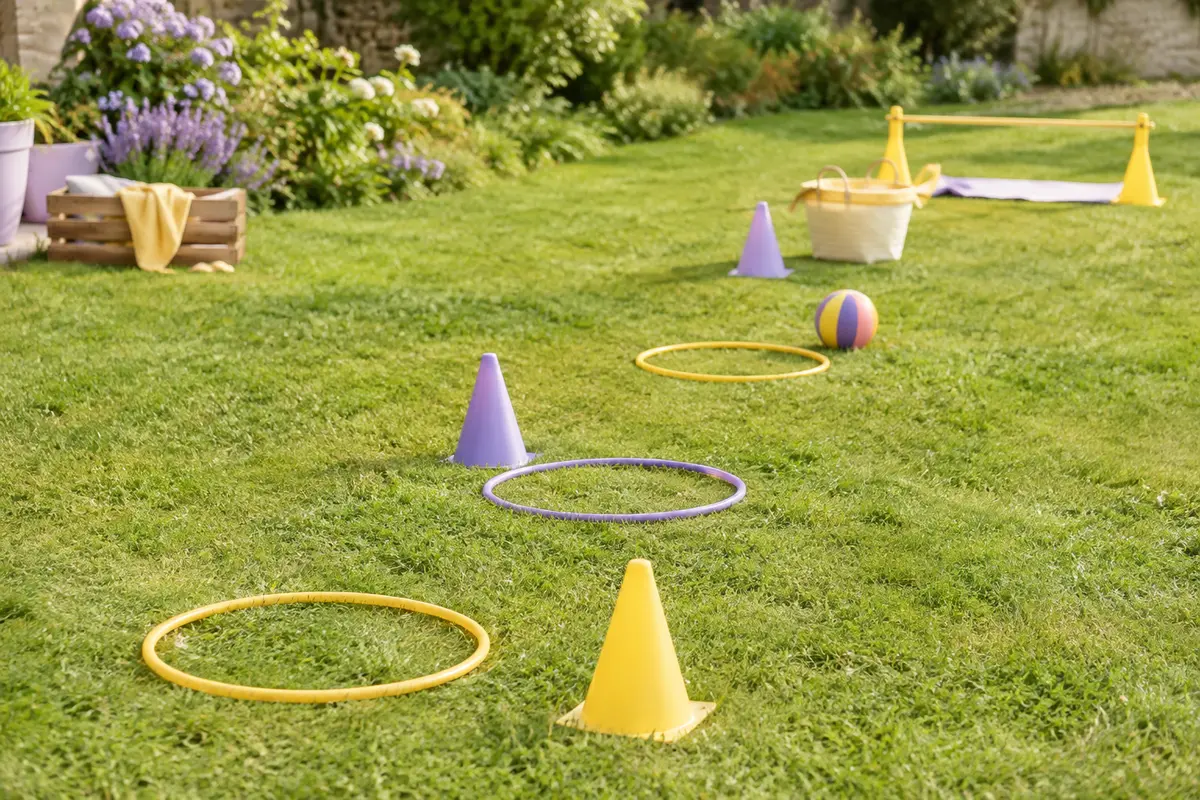 Parcours de jeux extérieur sur une pelouse avec cônes, cerceaux, balle et panier