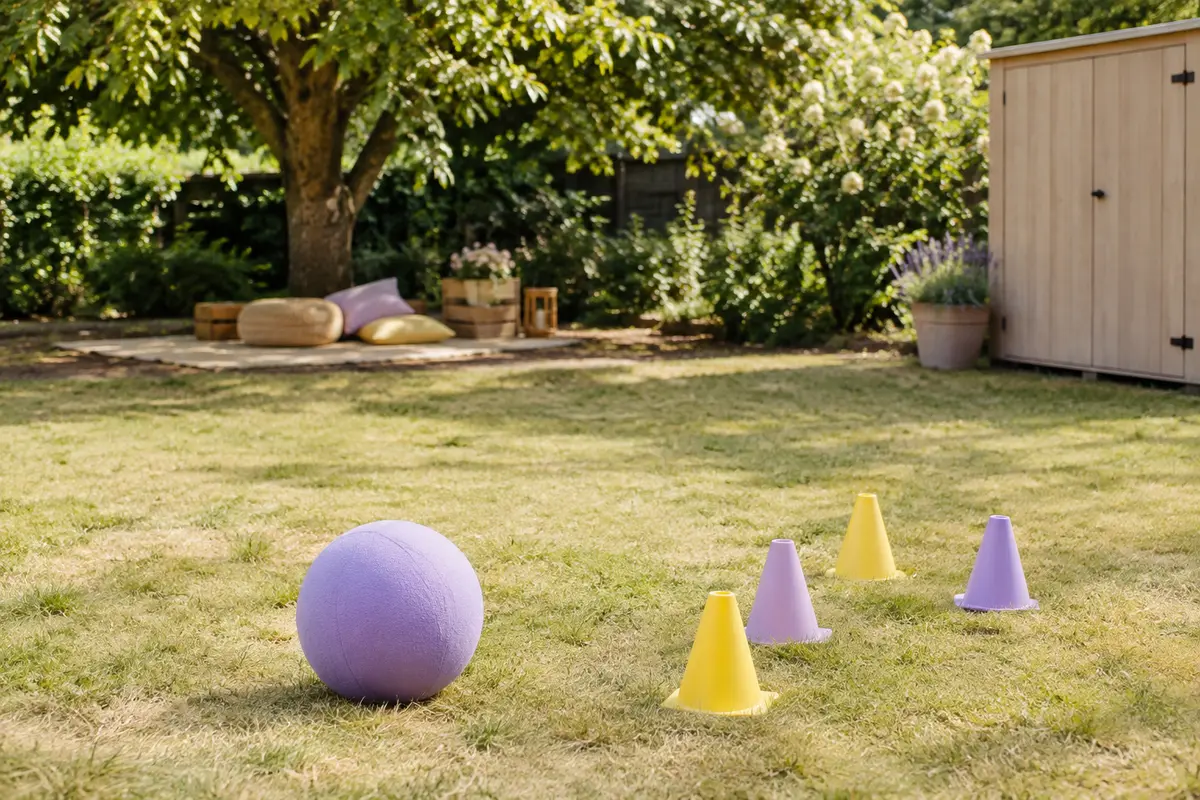 Espace de jardin dégagé avec ballon en mousse et cônes souples prêts pour un jeu extérieur