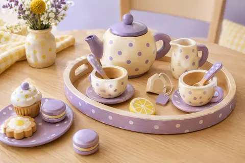 Service à thé en bois à pois avec théière, tasses, plateau et desserts sur une table claire