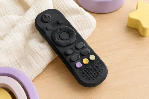 Jouet de dentition noir en silicone, en forme de télécommande avec des reliefs tactiles