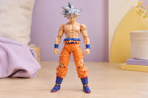 Figurine articulée Goku Ultra Instinct de 30 cm présentée sur une surface en bois clair dans un décor lilas et crème.