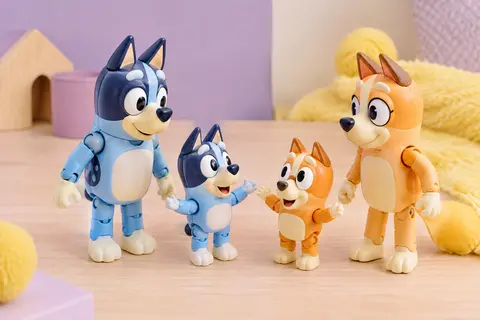 Quatre figurines articulées de Bluey, Bingo, Bandit et Chilli posées sur une surface en bois clair