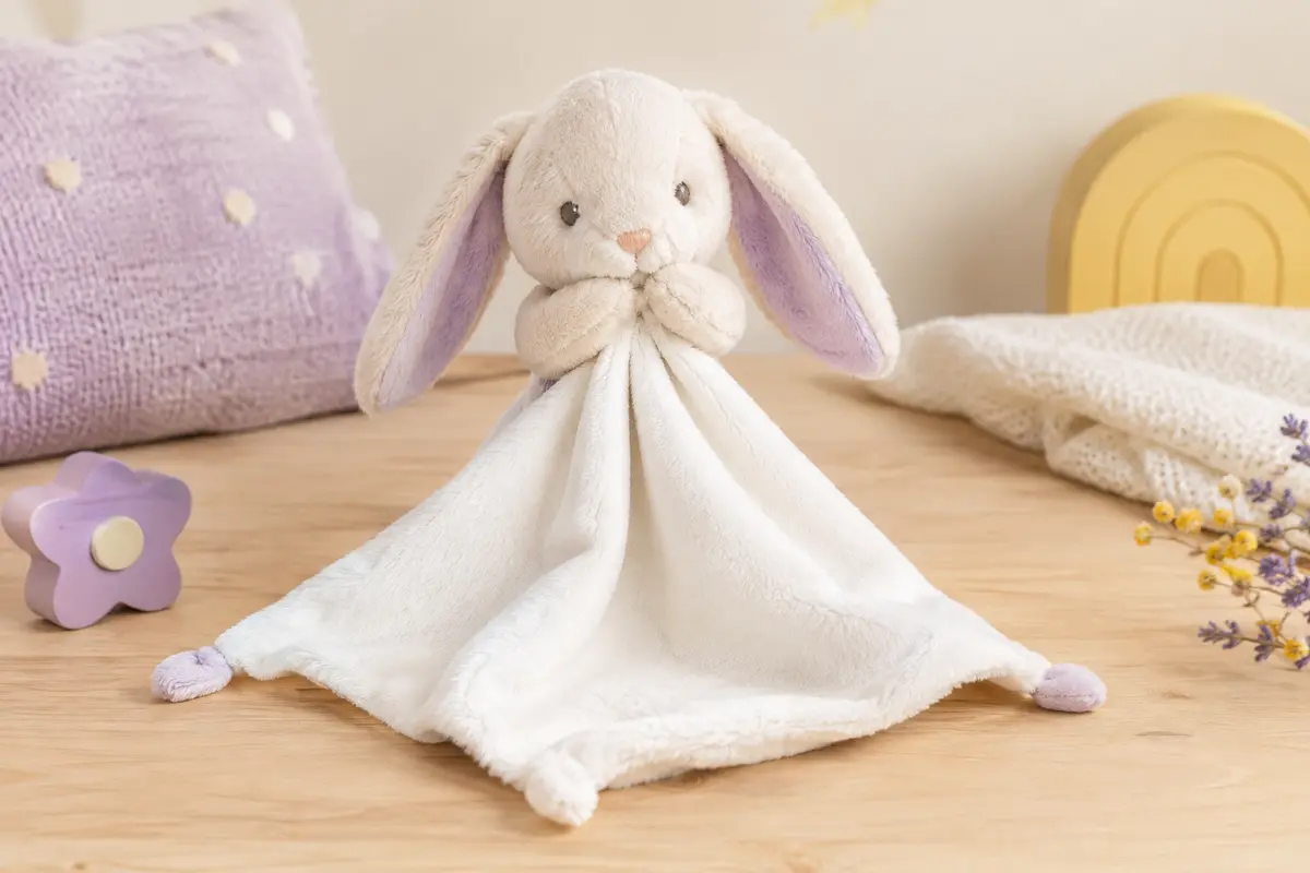 Doudou mouchoir blanc avec une tête de lapin, présenté sur un fond clair aux tons doux.