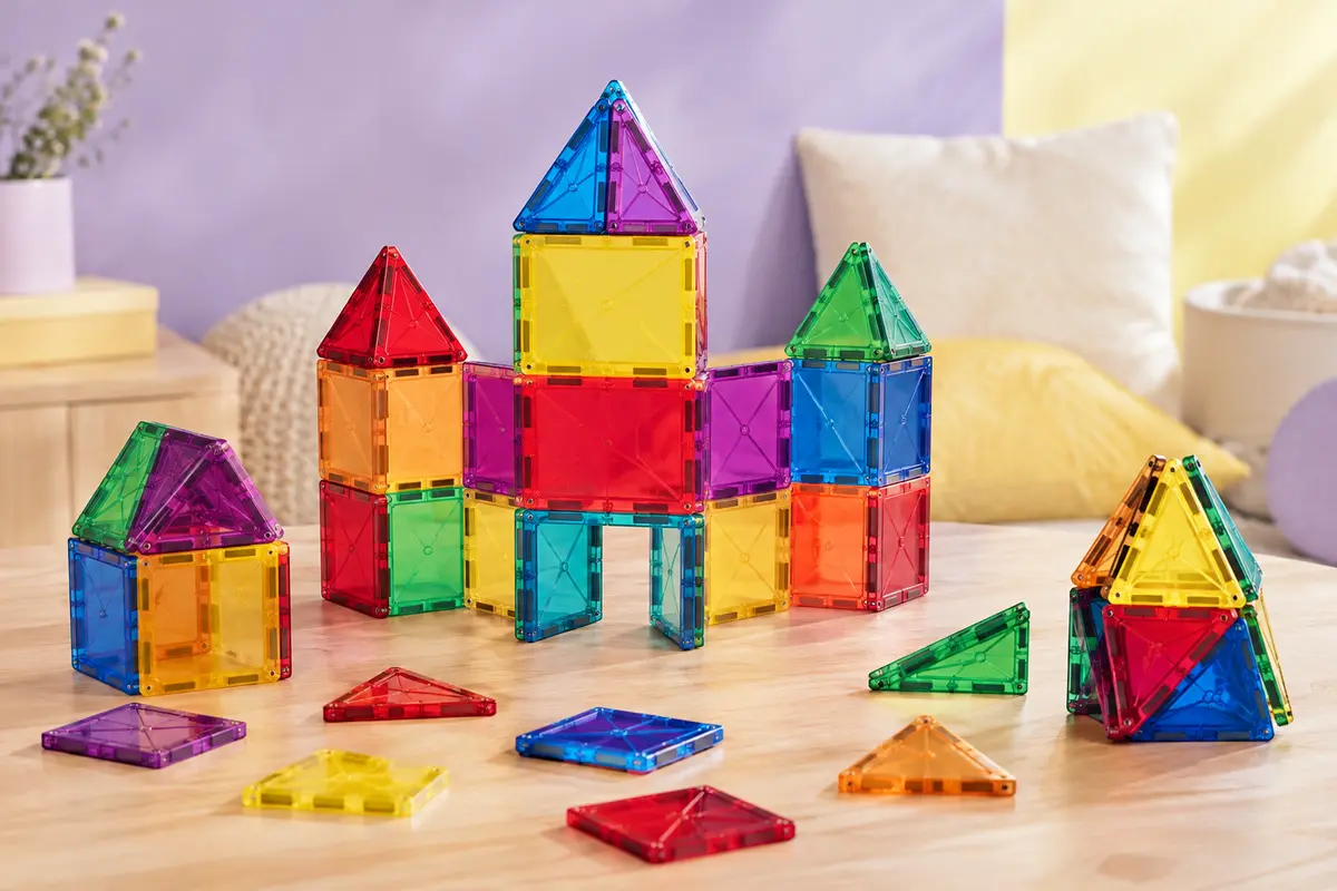 Tuiles magnétiques multicolores assemblées en château sur une table en bois clair