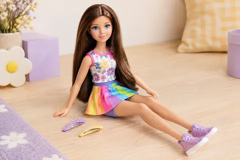 Poupée Kika de 36 cm aux cheveux bruns, avec une tenue colorée, des chaussures et deux barrettes.