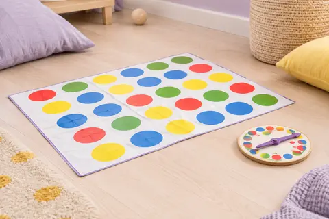 Tapis de jeu multicolore avec pastilles rouges, jaunes, bleues et vertes et tourniquet assorti