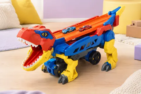 Transporteur Hot Wheels transformé en T-Rex, avec deux voitures sur sa piste à double voie.