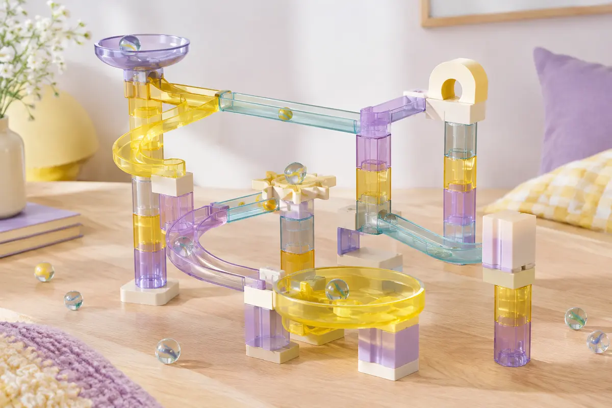 Circuit de billes JOYIN translucide assemblé sur une surface en bois clair avec des billes en verre