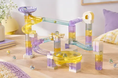 Circuit de billes JOYIN translucide assemblé sur une surface en bois clair avec des billes en verre