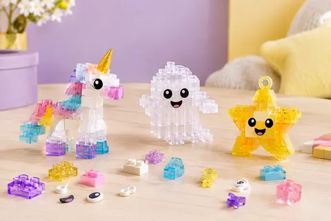Briques LEGO translucides et créations colorées, dont une licorne et un fantôme, sur un fond doux