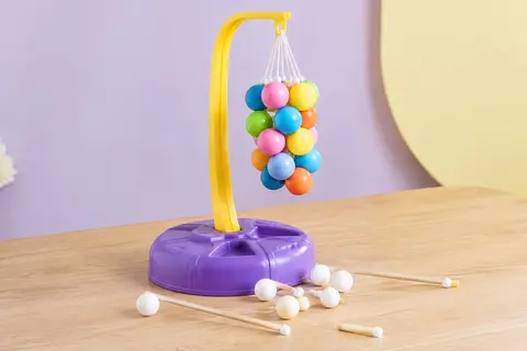 Jeu Badaboule avec sa grappe suspendue de boules colorées et ses boules blanches sur une table