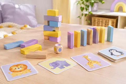 Blocs en bois multicolores, cartes d’animaux et dé réunis pour un jeu d’équilibre familial.
