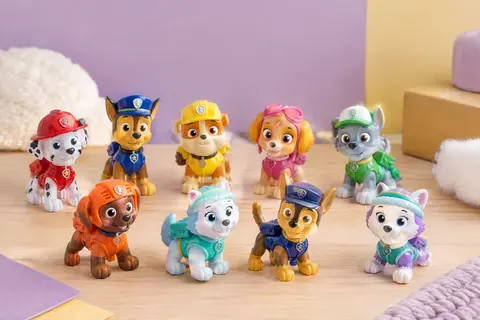Dix figurines multicolores de chiots Pat’ Patrouille réunies sur un décor doux en bois clair