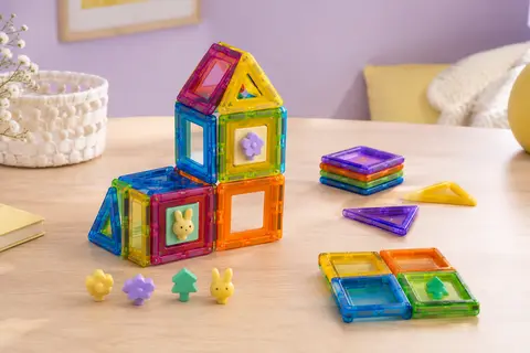 Tuiles magnétiques Playmags multicolores et éléments Clickins disposés autour d’une construction