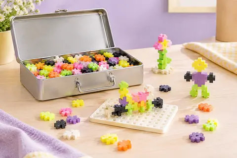 Valisette métallique ouverte avec briques de construction basic et néon et base de jeu.