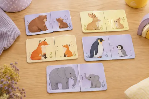 Cartes-puzzles en carton illustrant des mamans animales et leurs petits sur une table claire
