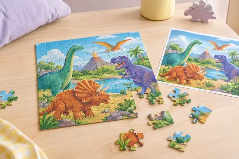 Puzzle carré de dinosaures en cours d’assemblage, avec pièces colorées et poster posé à côté