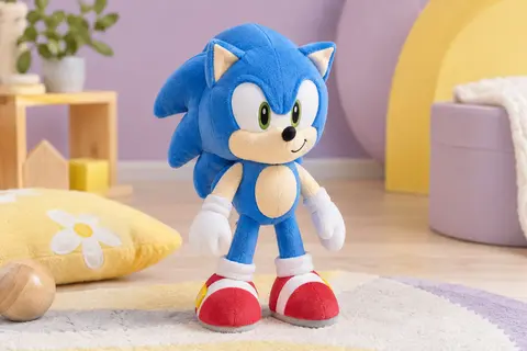 Peluche Sonic bleue à effet velours présentée debout dans un décor doux aux tons lilas et crème